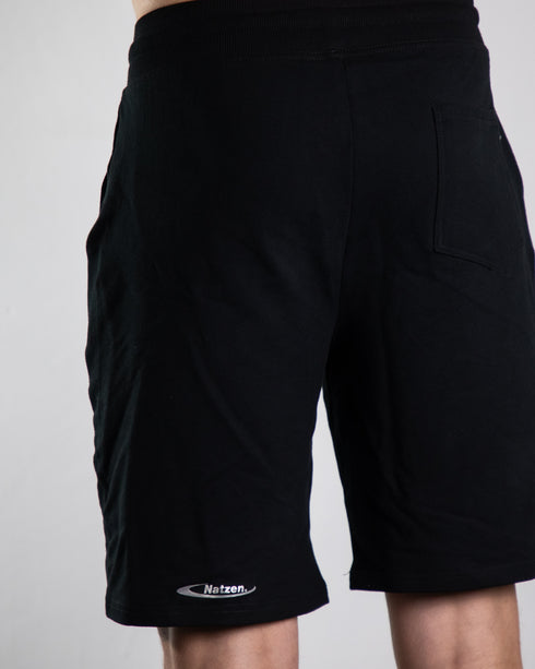 Kurze Raver Hose in schwarz mit "Natzen" Silberreflex Aufdruck am Hosenbein, von hinten fotografiert